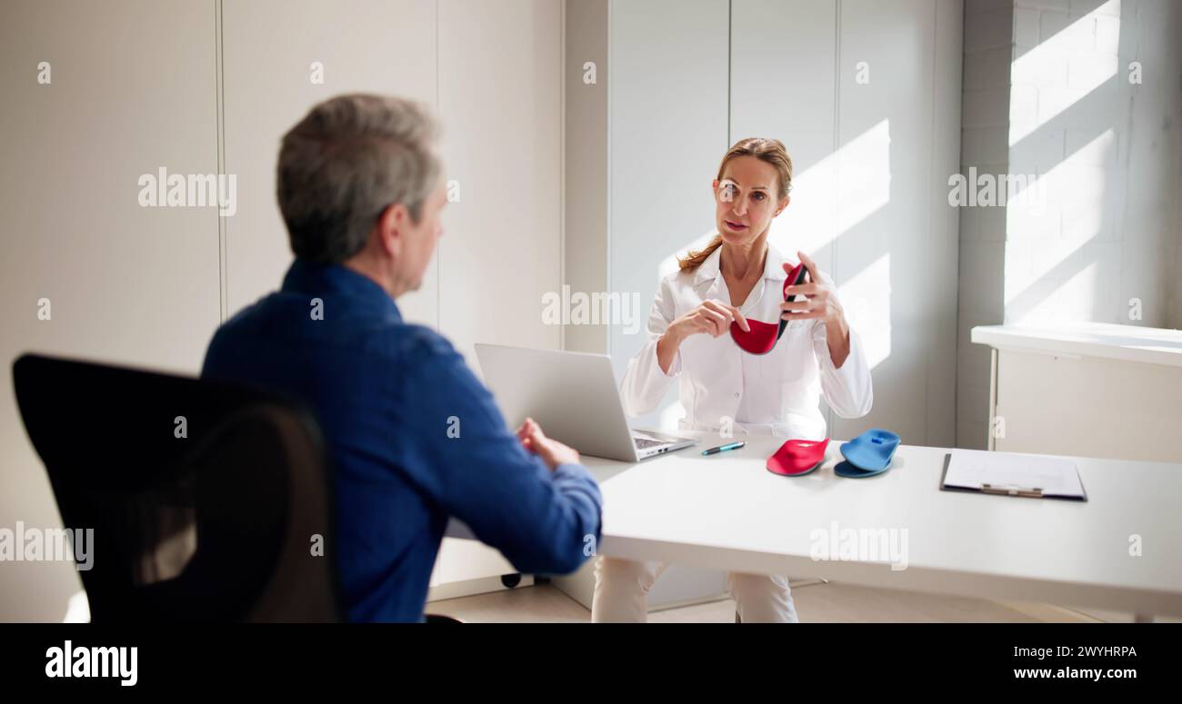 Orthopedist Doctor With Orthopedic Shoe Insole Consulting Patient Stock Photo