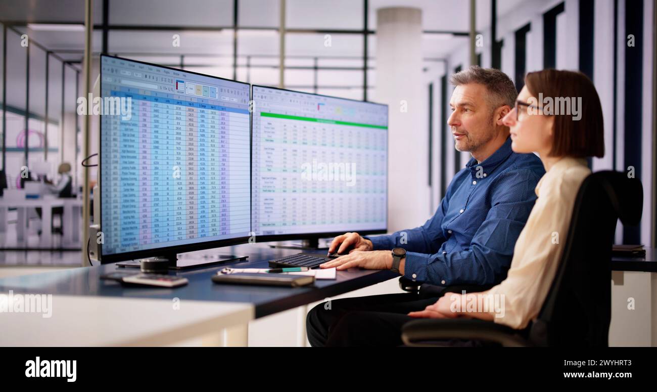 Analyst Employee Working On Spreadsheet Using Desktop Computer Stock Photo