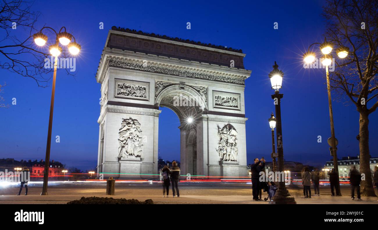 The Triumphal Arch commemorates the French Revolution, the Napoleonic Wars and WW 1. Tourist take pictures with the monument in the background. Shot a Stock Photo