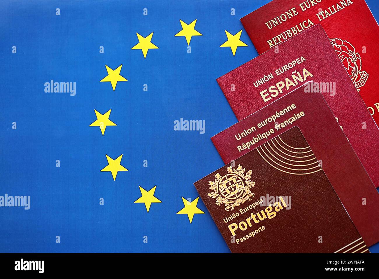 European union countries passports on blue EU flag close up. Portugal, Spanish, French and Italian passports Stock Photo