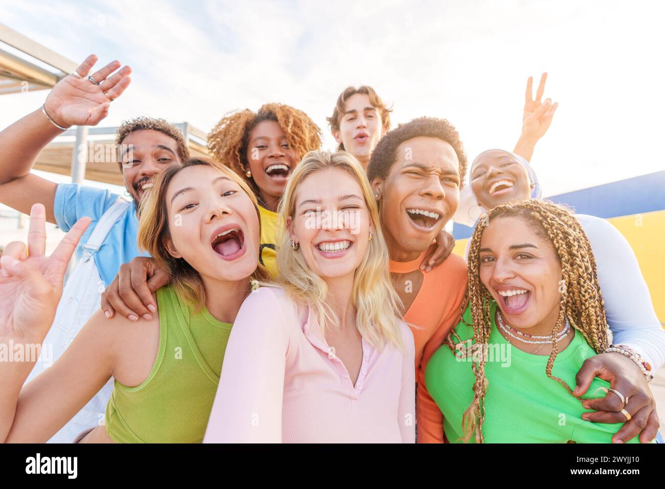 Happy blonde woman taking selfie with multiethnic friends Stock Photo