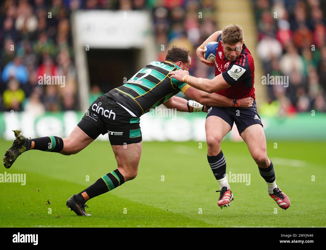 Munster’s Jack Crowley is tackled by Northampton Saints' Burger Odendaal during the ECPR Challenge Cup match at cinch Stadium at Franklin's Gardens, Northampton. Picture date: Sunday April 7, 2024. Stock Photo