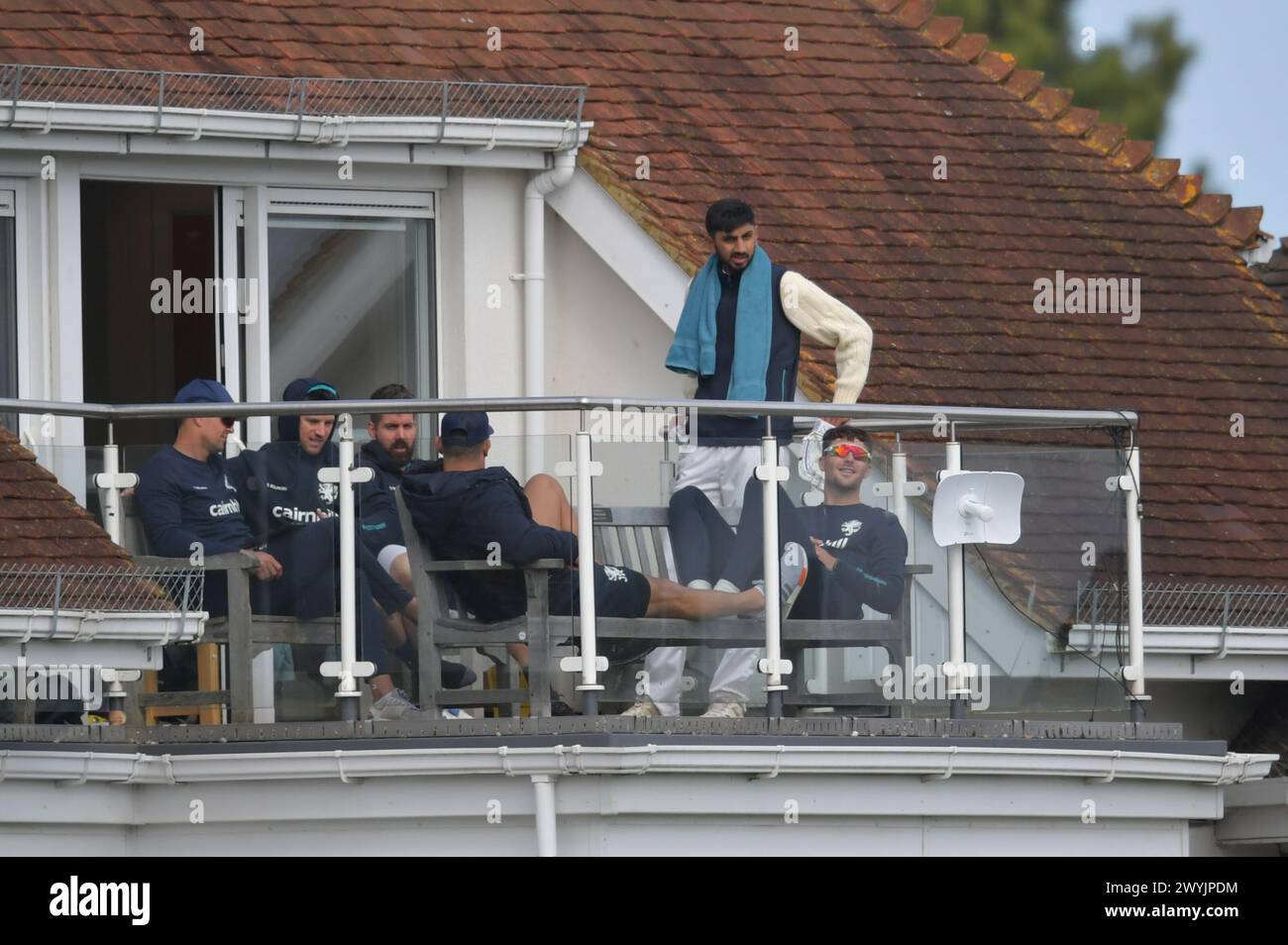 Canterbury, England. 7th Apr 2024. Shoaib Bashir of Somerset and England (far right) watches from the balcony during day three of the Vitality County Championship Division One fixture between Kent County Cricket Club and Somerset County Cricket Club at the Spitfire Ground, St Lawrence. Kyle Andrews/Alamy Live News. Stock Photo