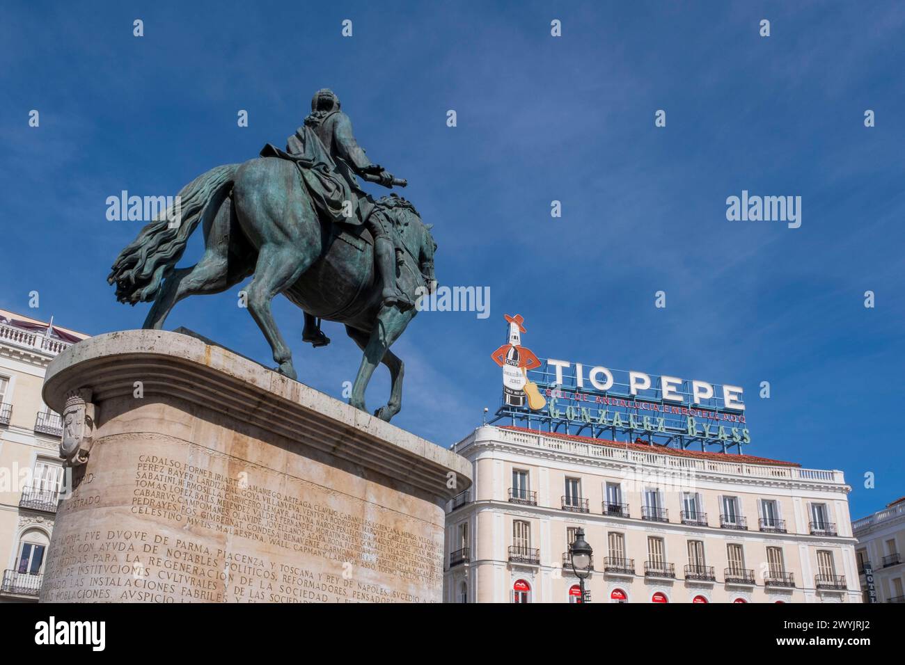 Spain, Madrid, Puerta del Sol, equestrian statue of King Charles III and wines Tio Pepe billboard advertisement on a roof of a building Stock Photo