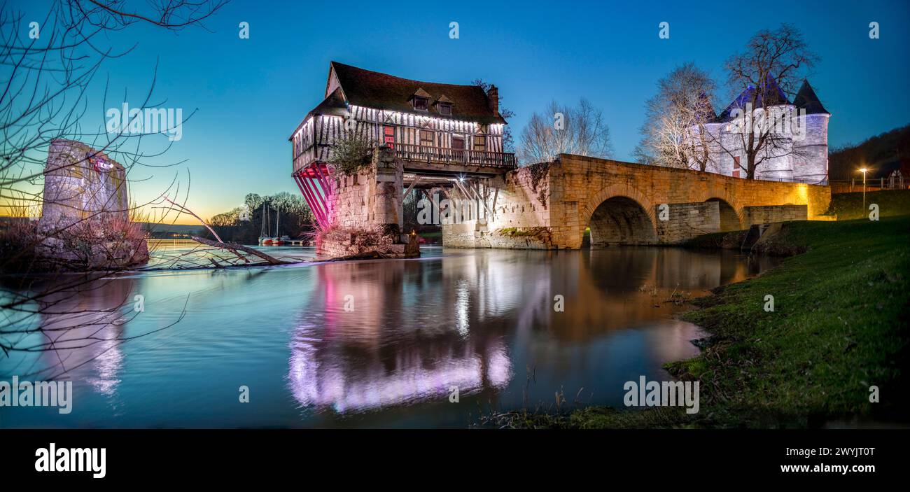 France, Eure, Vernon, reflection of the Old Mill on the water of the Seine river, illuminated at sunset Stock Photo