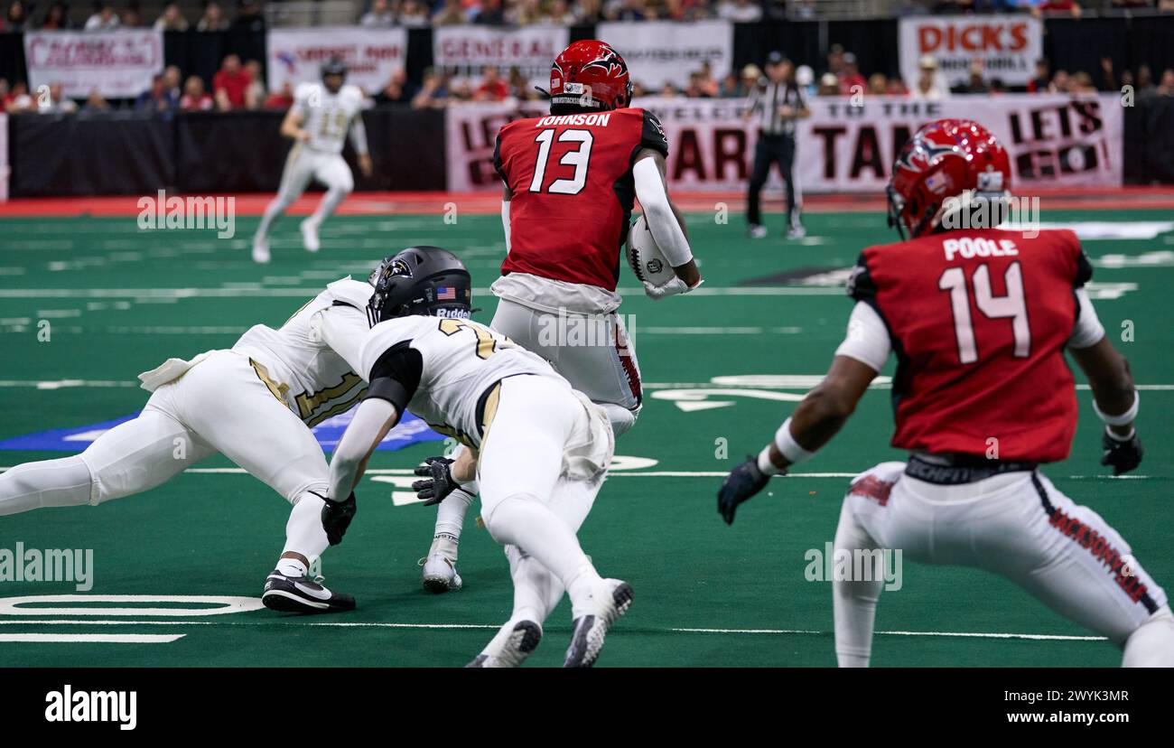 WR Isaiah Johnson (#13) splits two defenders, DB Desmond Williams (#10) and DB Tyler Watson (#24), for a moderate gain. Photo Credit: Tim Davis/Alamy Live News Stock Photo