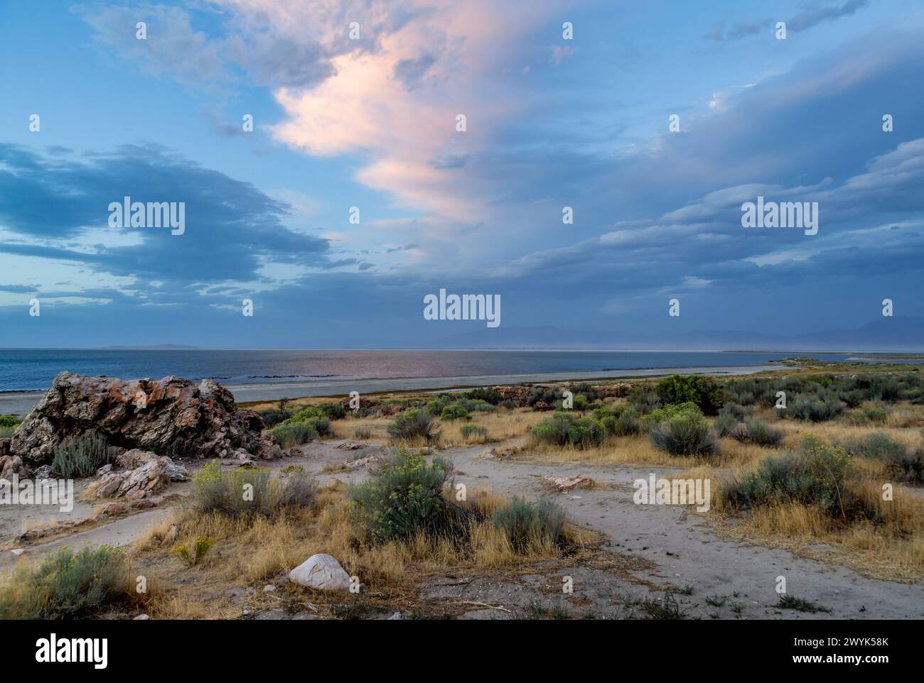 Setting sun lights up the clouds along the shoreline of Great Salt Lake in the Antelope Island State Park near Syracuse, Utah Stock Photo