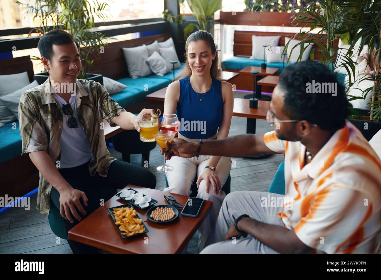 Cheerful friends having drinks in bar after work Stock Photo