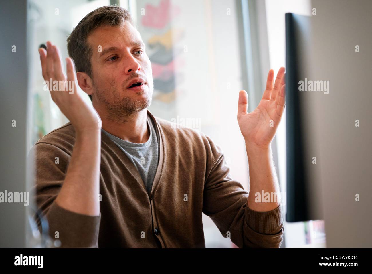 Portrait of a disappointed man programmer looking stressed out while working on a computer code Stock Photo