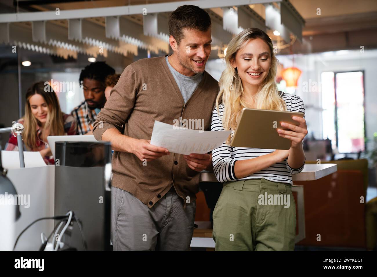 Close up diverse colleagues using tablet together, discussing online project Stock Photo