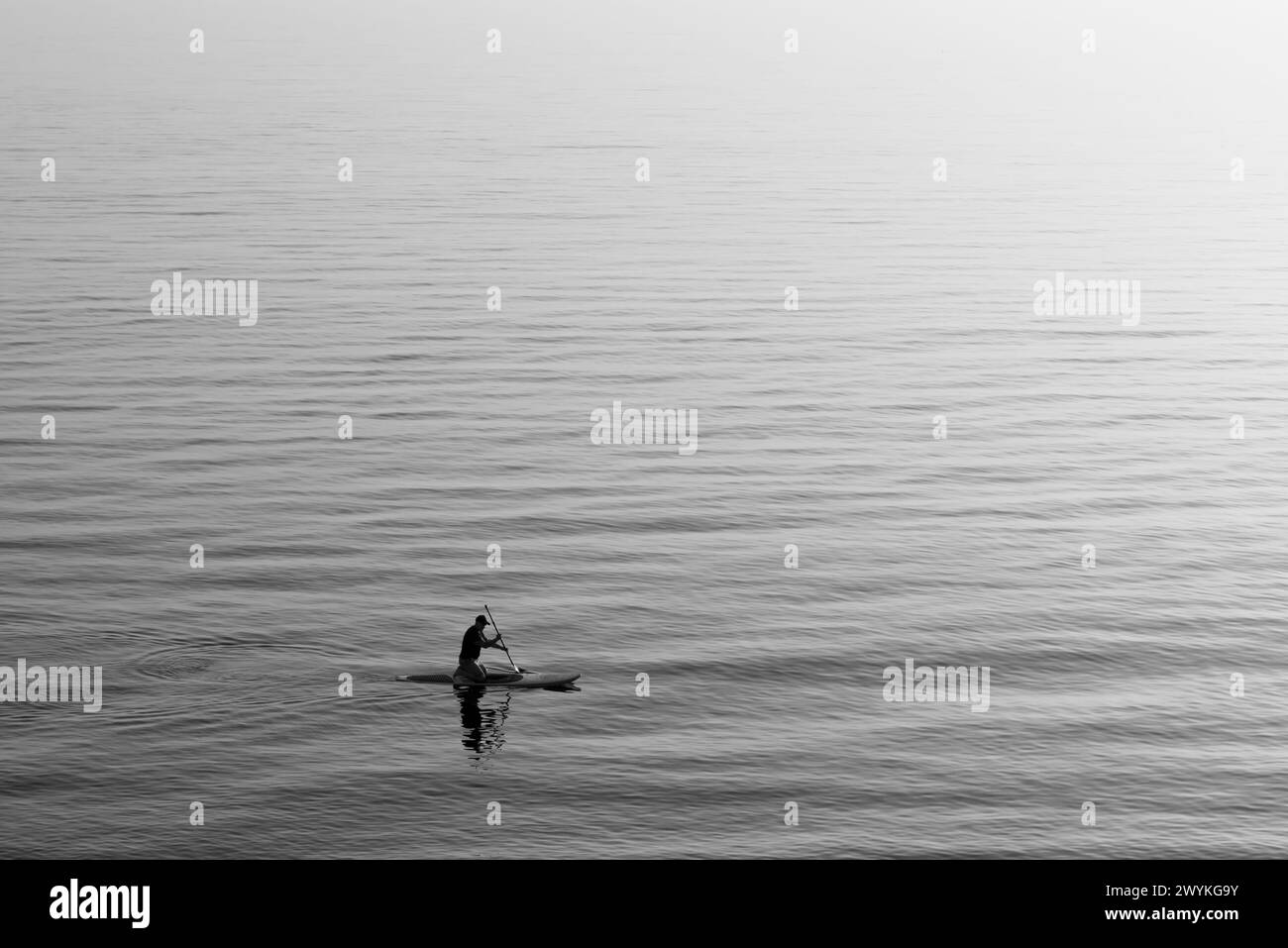 Silhouette of man paddle boarding Stock Photo