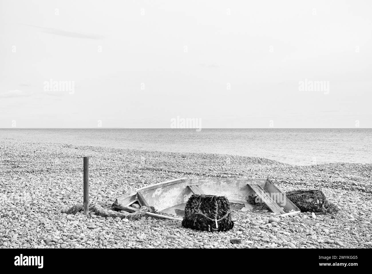 Boat and lobster pots abandoned on the beach Stock Photo