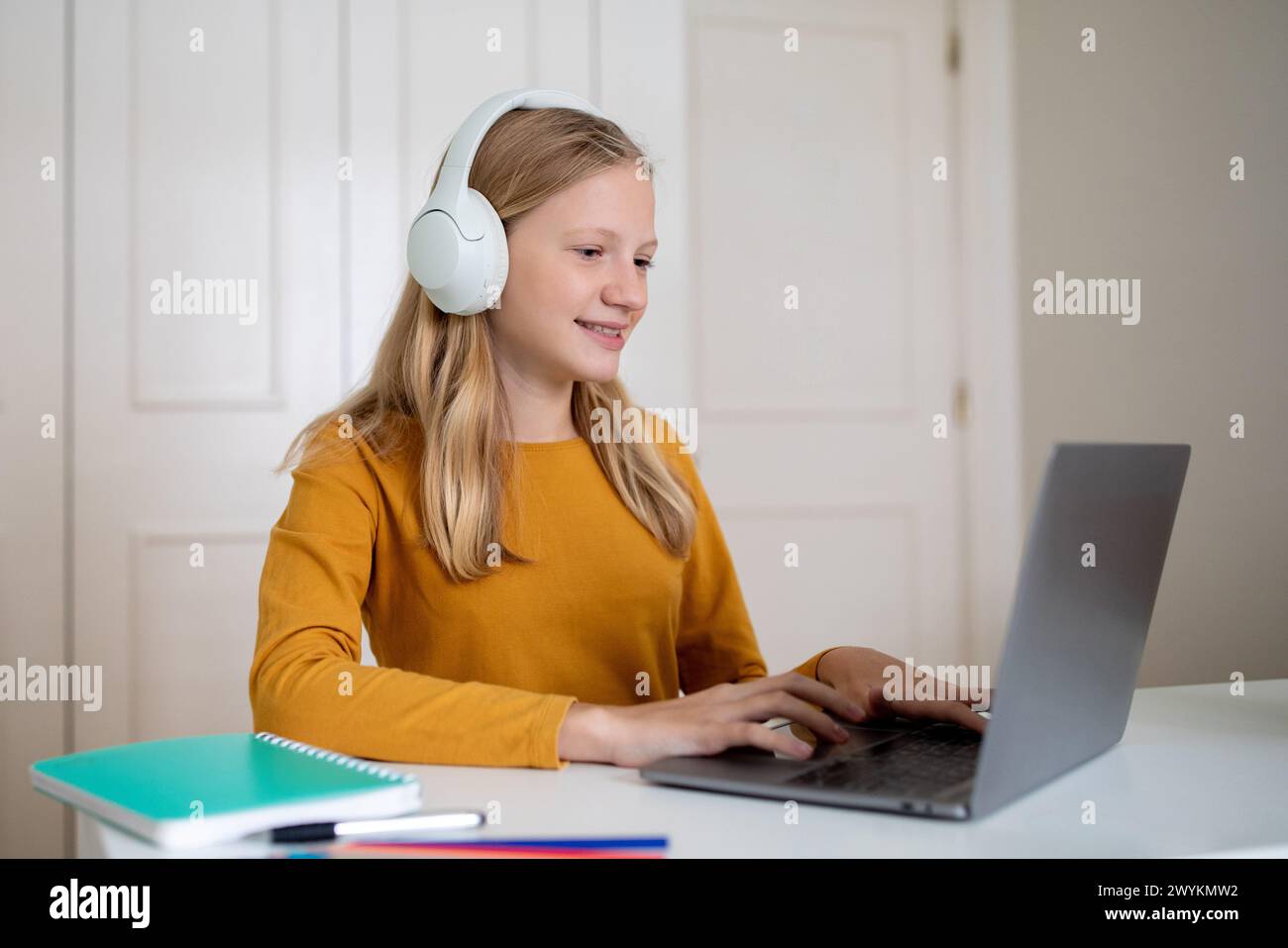 Teen Girl Using Laptop And Headphones at Desk Stock Photo - Alamy