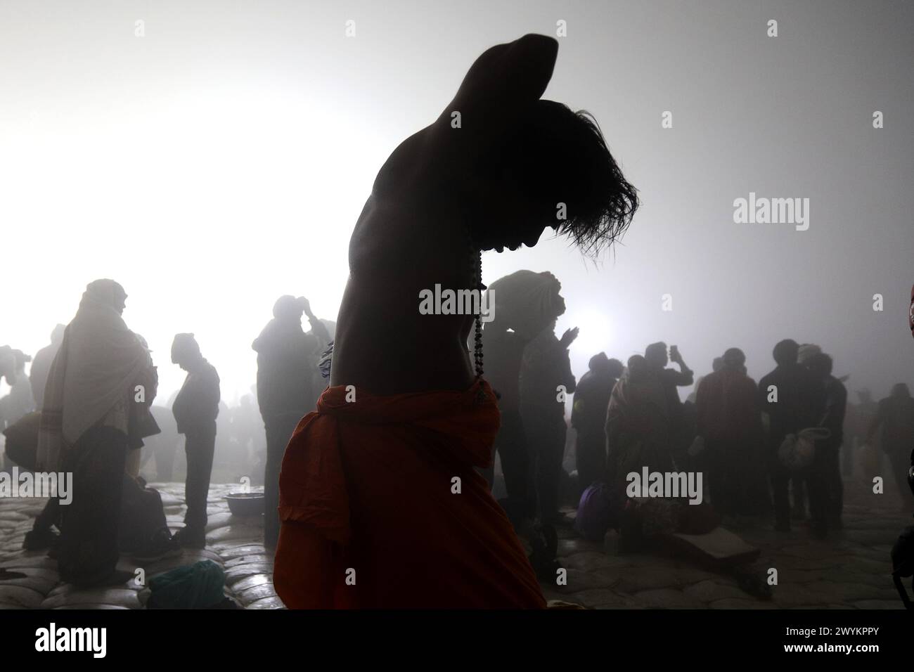 An Indian holy man prepares himself after taking holy dip in river Ganges on the occasion of Makar sankranti during Magh Mela 2024 in Prayagraj, India. Stock Photo