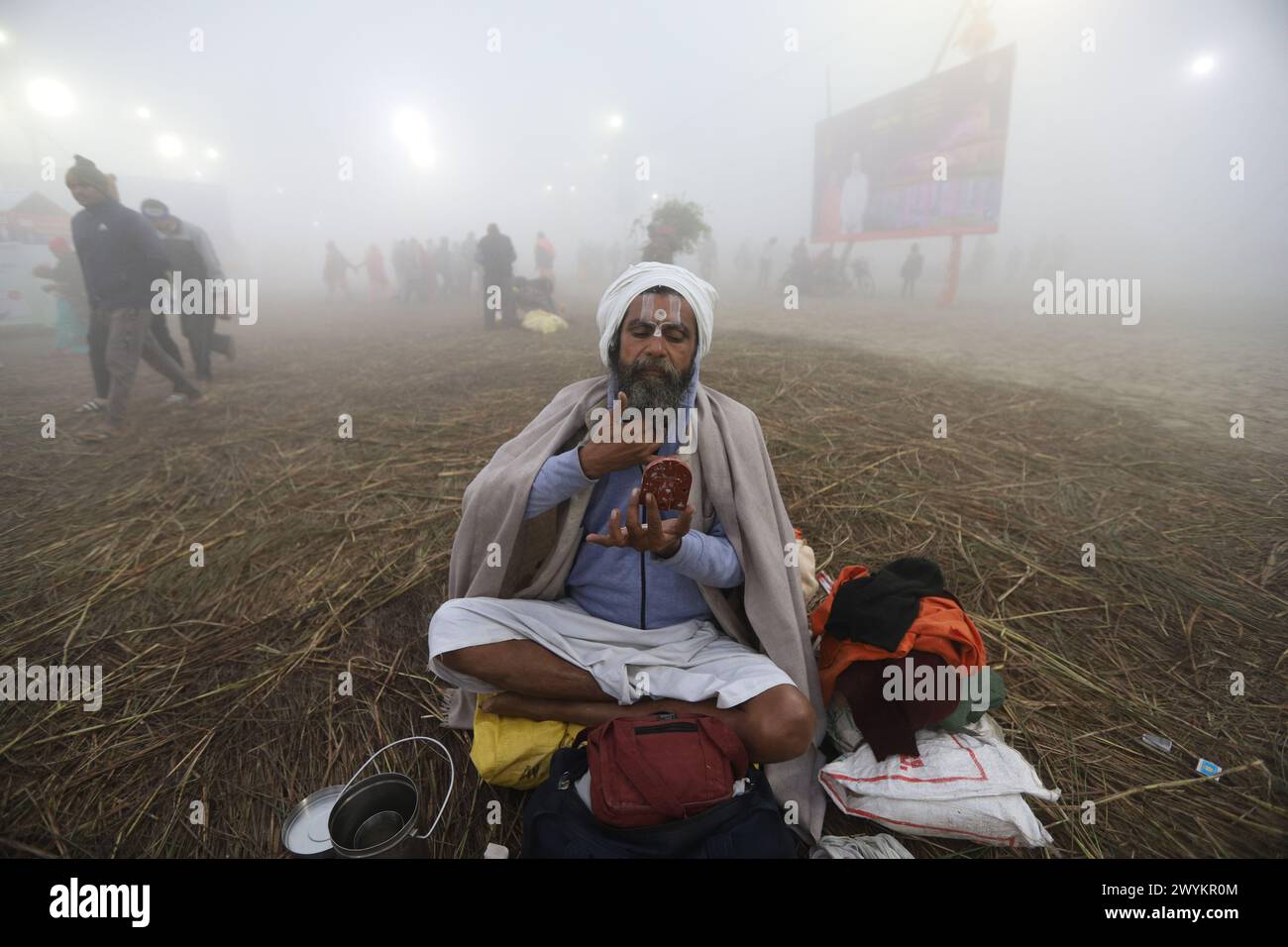 An Indian holy man prepares himself after taking holy dip in river Ganges on the occasion of Makar sankranti during Magh Mela 2024 in Prayagraj, India Stock Photo