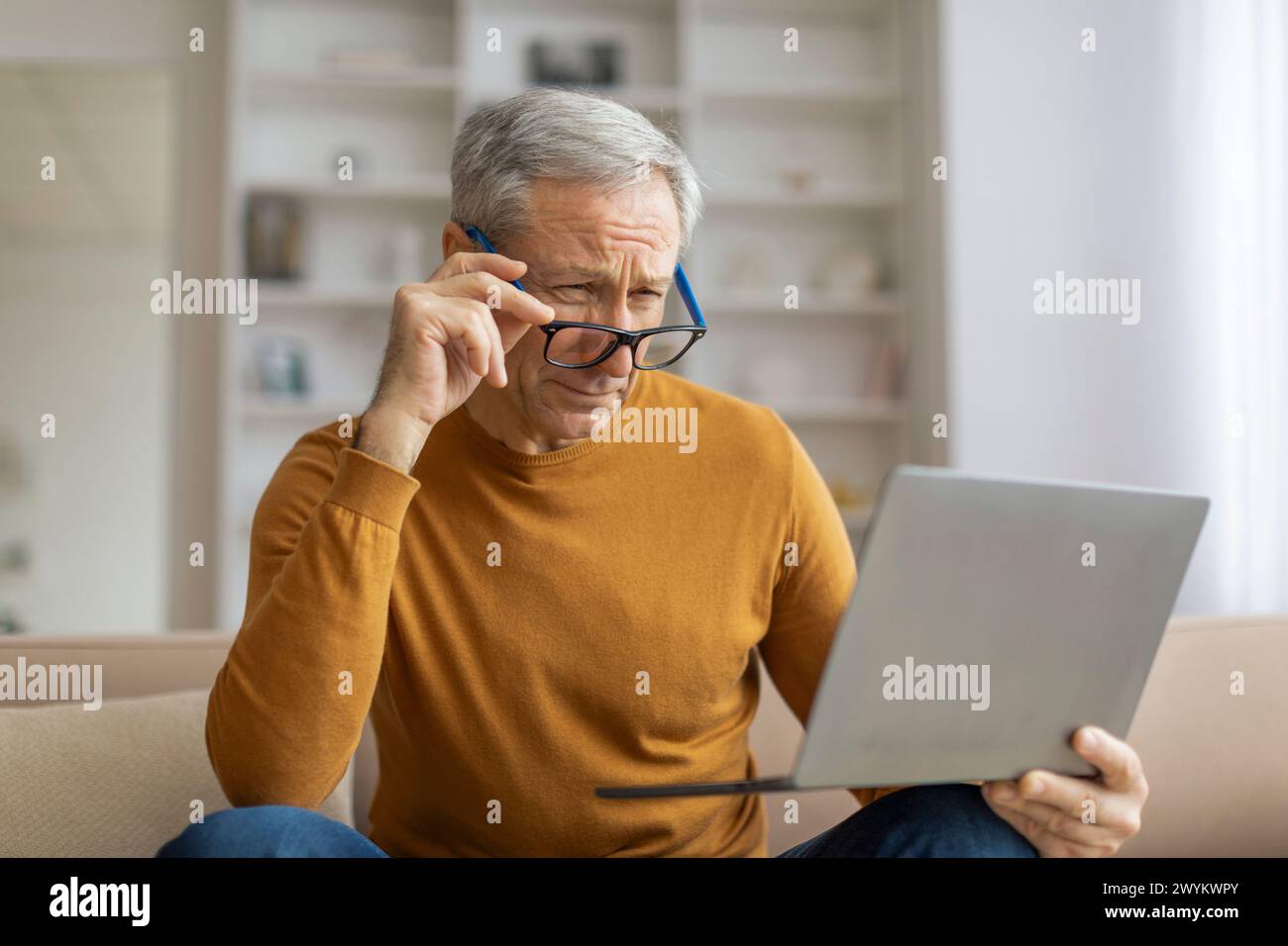 Mature man using laptop at home with a concentration Stock Photo
