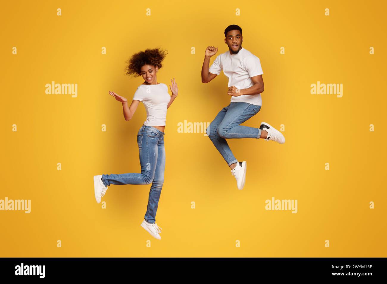 Carefree african american man and woman jumping in air Stock Photo - Alamy