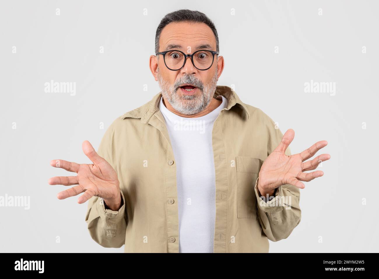 Surprised senior bearded man with open hands Stock Photo