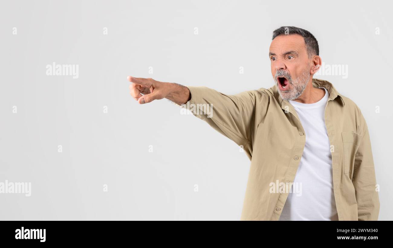 Shocked senior man pointing with an open mouth Stock Photo