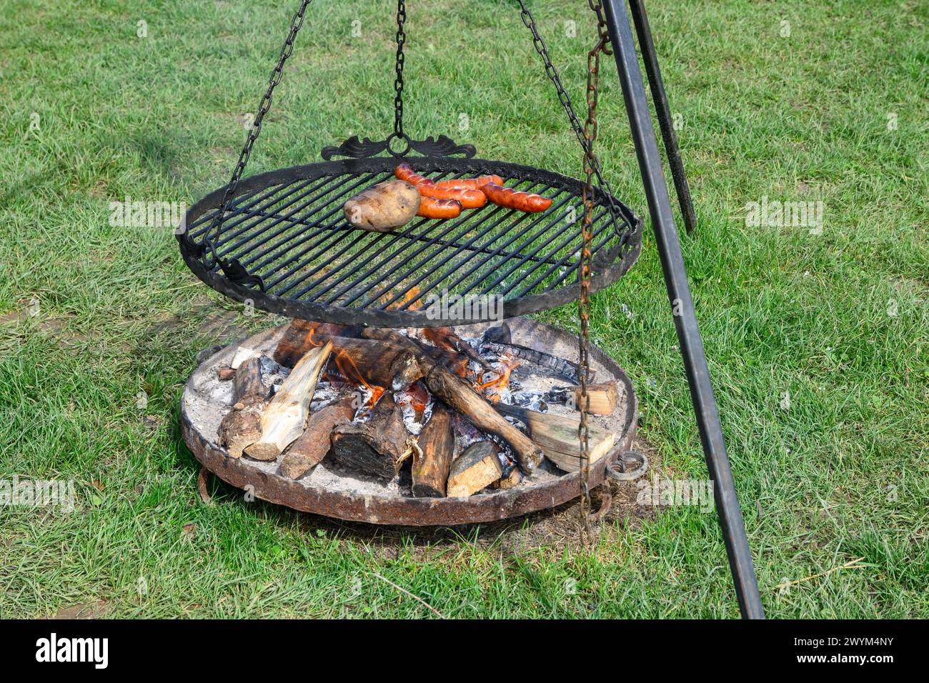 Grilling sausages and potato on barbecue grill. Barbeque grill fireplace Stock Photo