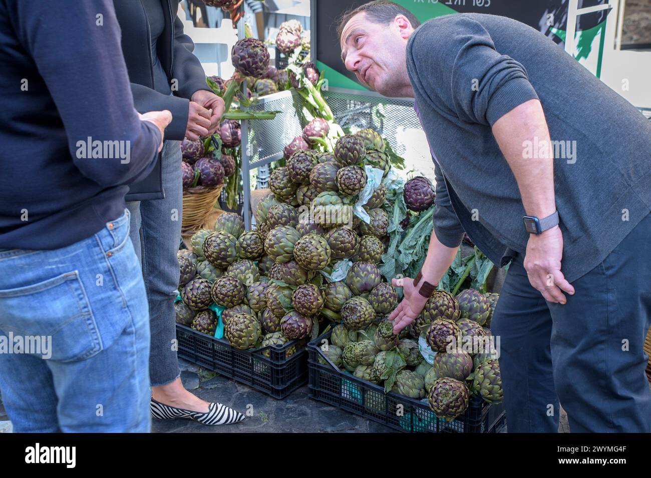 Rome, Italy. 7th Apr, 2024. David sells some artichokes for charity in front of his pizzeria during the Roman Artichoke Festival in Rome. The Roman Artichoke Festival has begun in the former Jewish Ghetto in Rome. The Roman Artichoke is a typical variety of the Lazio region, in addition to being a cornerstone of the Mediterranean diet, it is a fundamental ingredient of the Roman and Judeo-Roman culinary tradition, which has seen its use in numerous recipes, famous throughout the world. (Credit Image: © Marcello Valeri/ZUMA Press Wire) EDITORIAL USAGE ONLY! Not for Commercial USAGE! Stock Photo