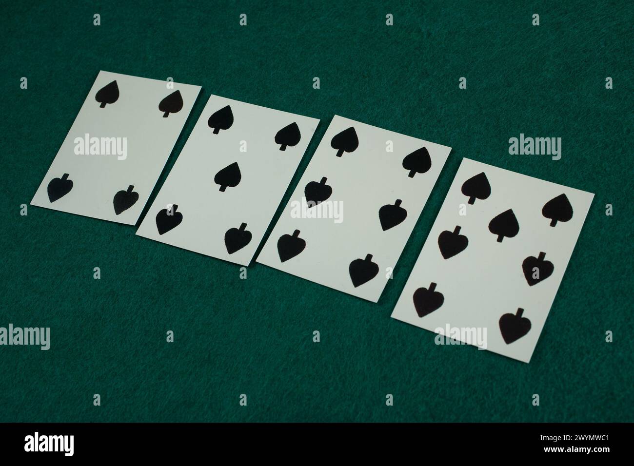 Old west era playing card on green gambling table. 4, 5, 6, 7 of spades. Stock Photo