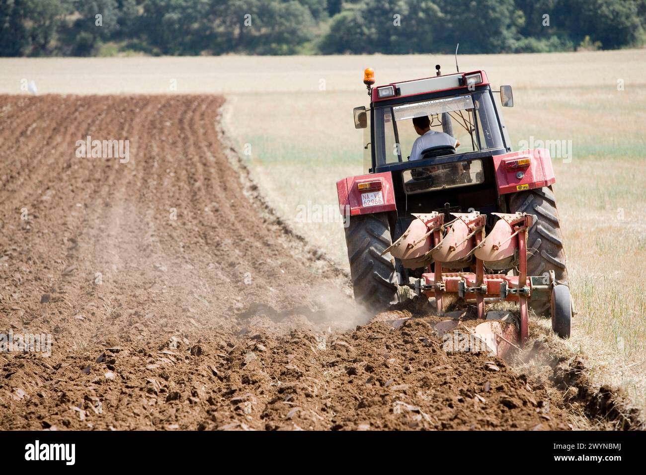 Agricultural machinery. Tractor ploughing the land. Mouldboard plough. Harvesting of cereals, Oco (near Estella), Navarre, Spain. Stock Photo