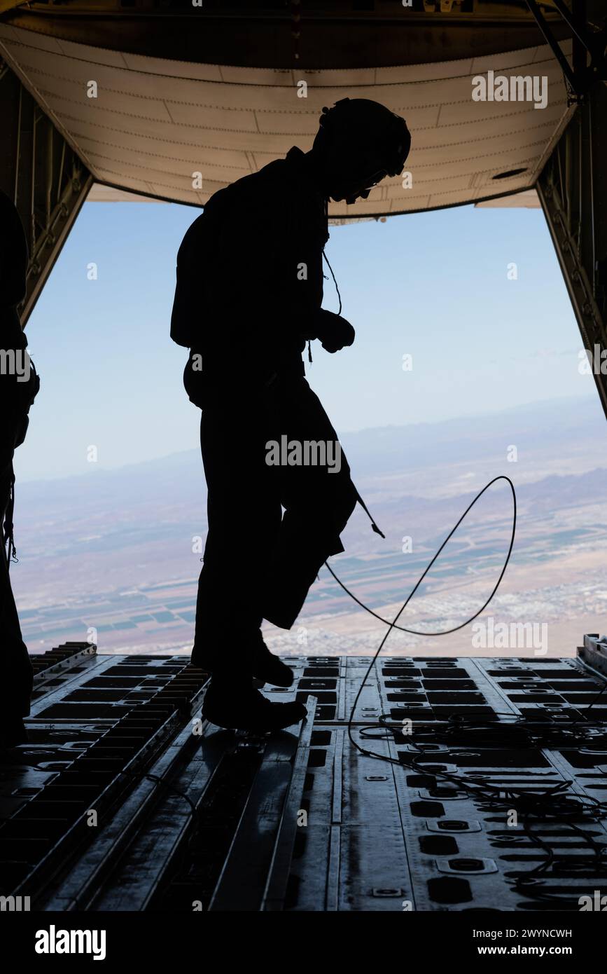 A U.S. Marine, assigned to Marine Aviation Weapons and Tactics Squadron One, participates in a KC-130J Hercules aircraft airdrop maneuvers exercise as part of Weapons and Tactics Instructor course 2-24, near Yuma, Arizona, April 2, 2024. WTI is an advanced graduate-level course that provides advanced tactical training to enhance and employ advanced aviation weapons and tactics. (U.S. Marine Corps photo by Lance Cpl. Elizabeth Gallagher) Stock Photo