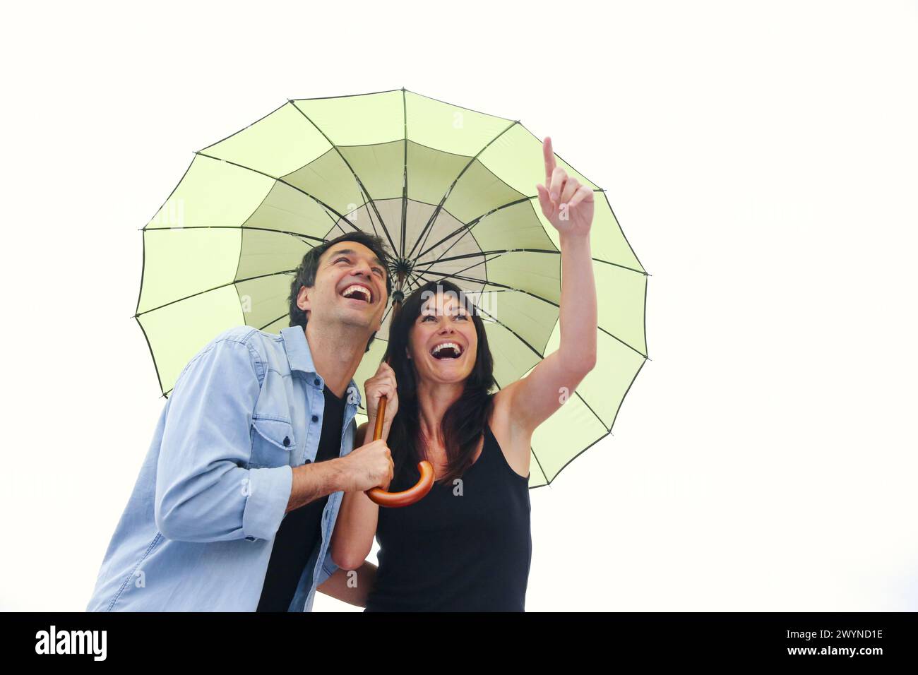 Couple in their 30´s smiling under umbrella Stock Photo - Alamy