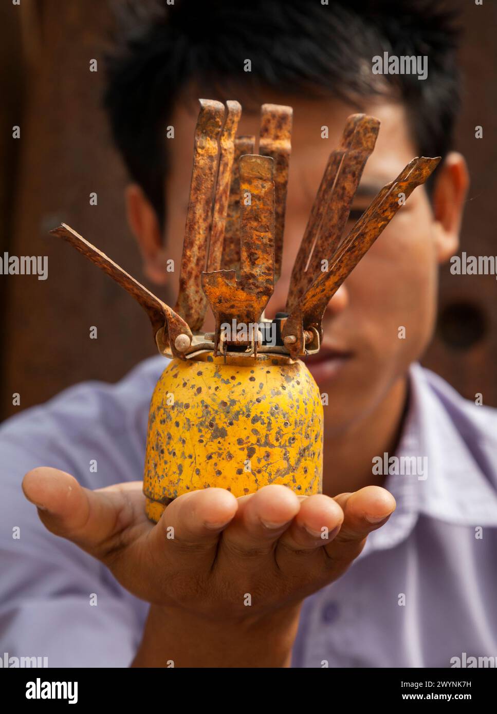 Deadly legacy from the Vietnam War. Local villager holds an American BLU3 cluster bomb. Xiangkhouang, Province, Laos. Stock Photo