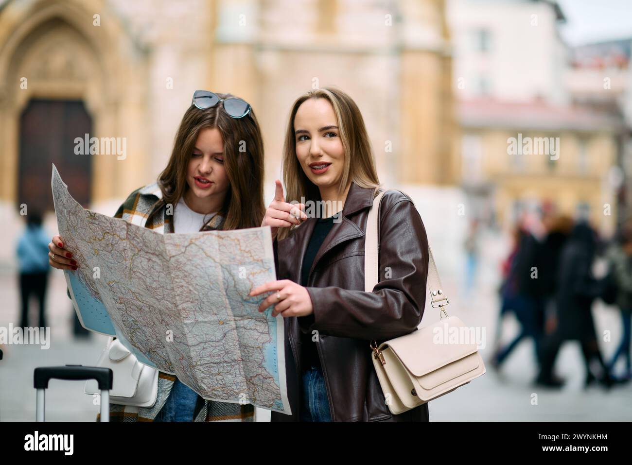 Two female tourists engage in lively discussion, surrounded by their ...