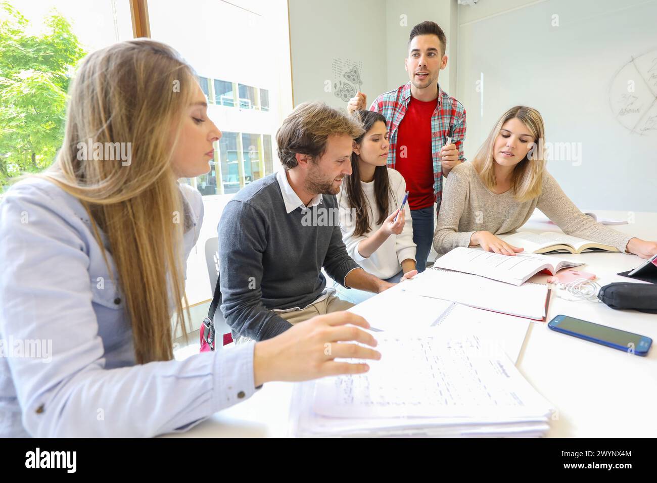 Teacher with group of students doing a joint work, University of the ...