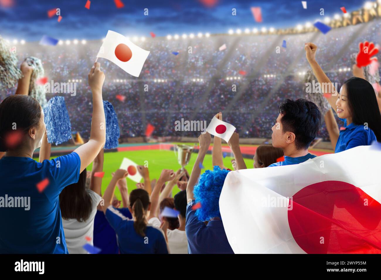 Japan football supporter on stadium. Japanese fans on soccer pitch watching team play. Group of supporters with flag and national jersey cheering Stock Photo