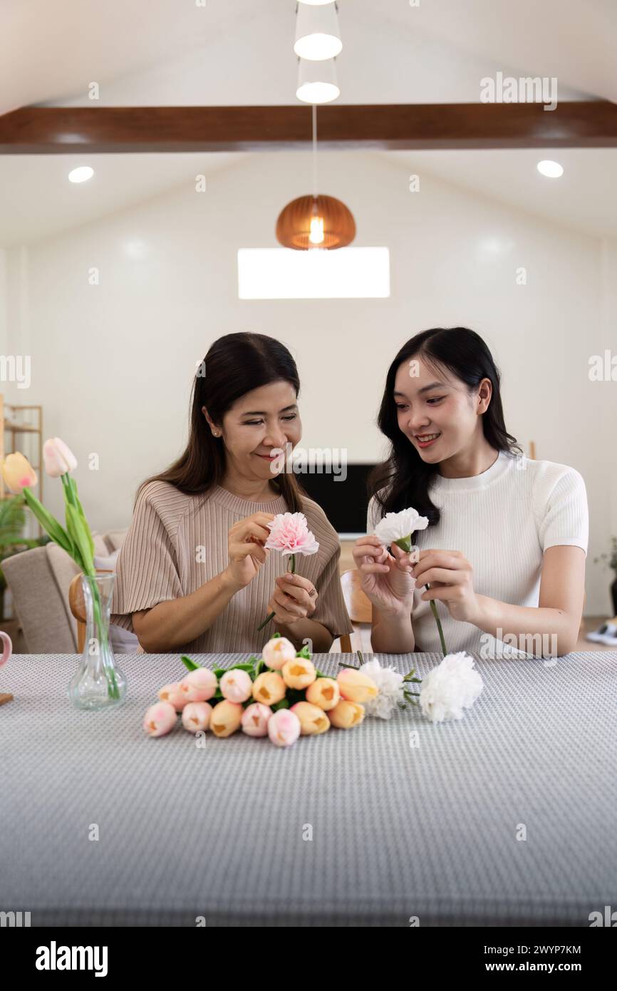 Senior mother and adult daughter happy on the table while arrange ...