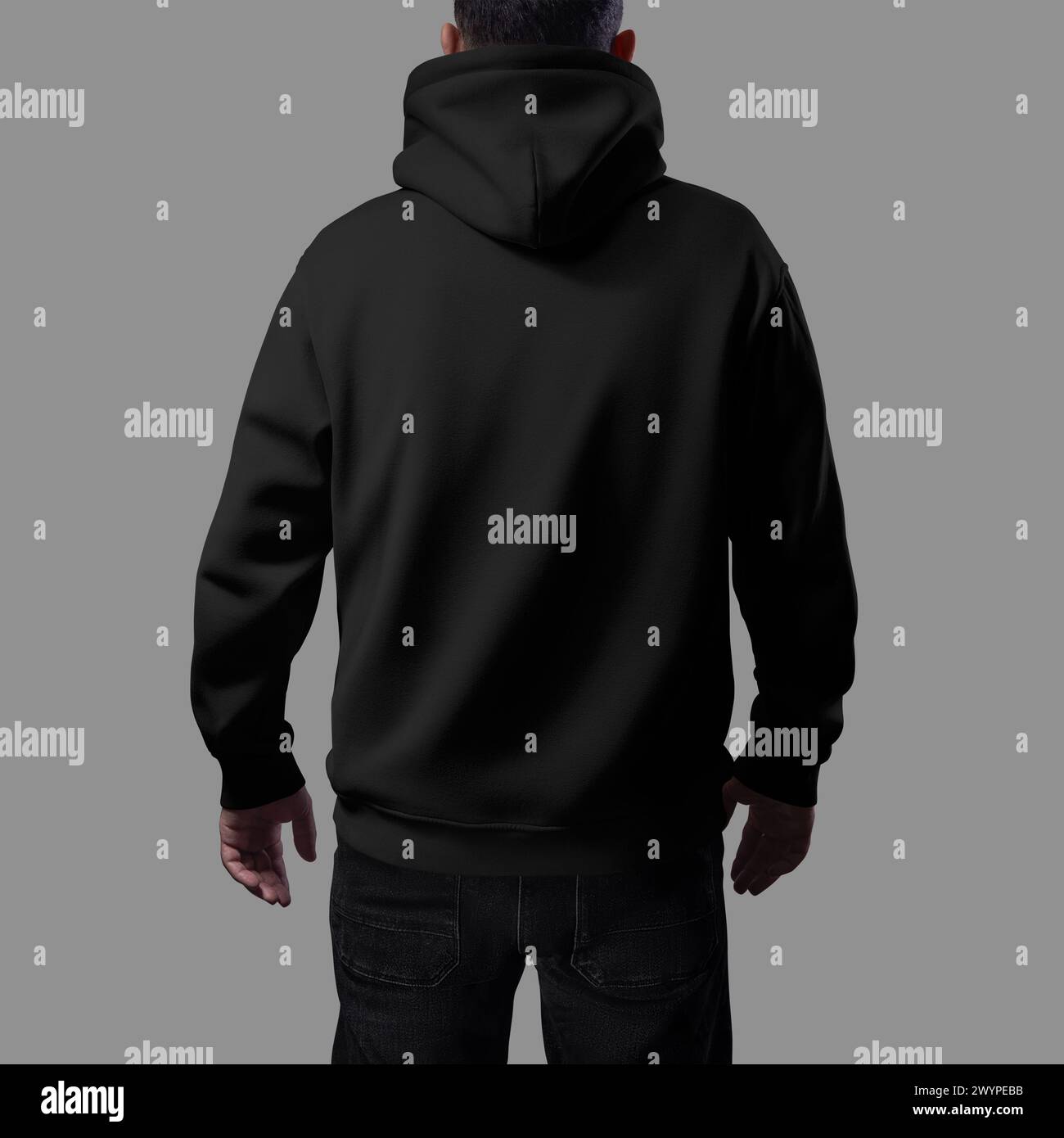 Mockup of a black oversized hoodie on a man in dark jeans, close-up rear view, loose clothes for design, branding, advertising. Texture streetwear tem Stock Photo