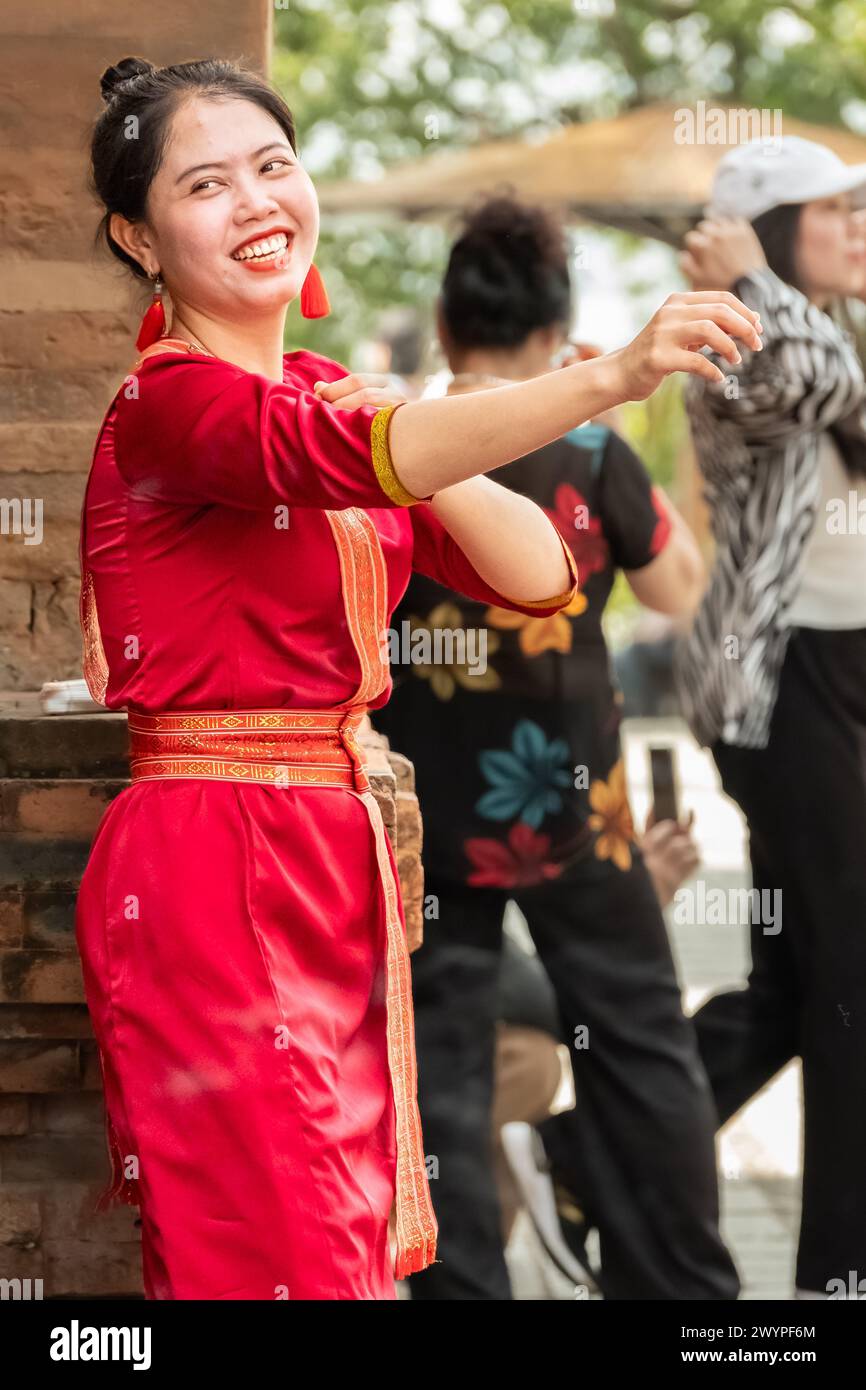 Photo of smiling young Vietnamese woman wearing red ao dai. Vietnam woman wearing Ao Dai culture traditional at old temple at Nha Trang in Vietnam-Mar Stock Photo