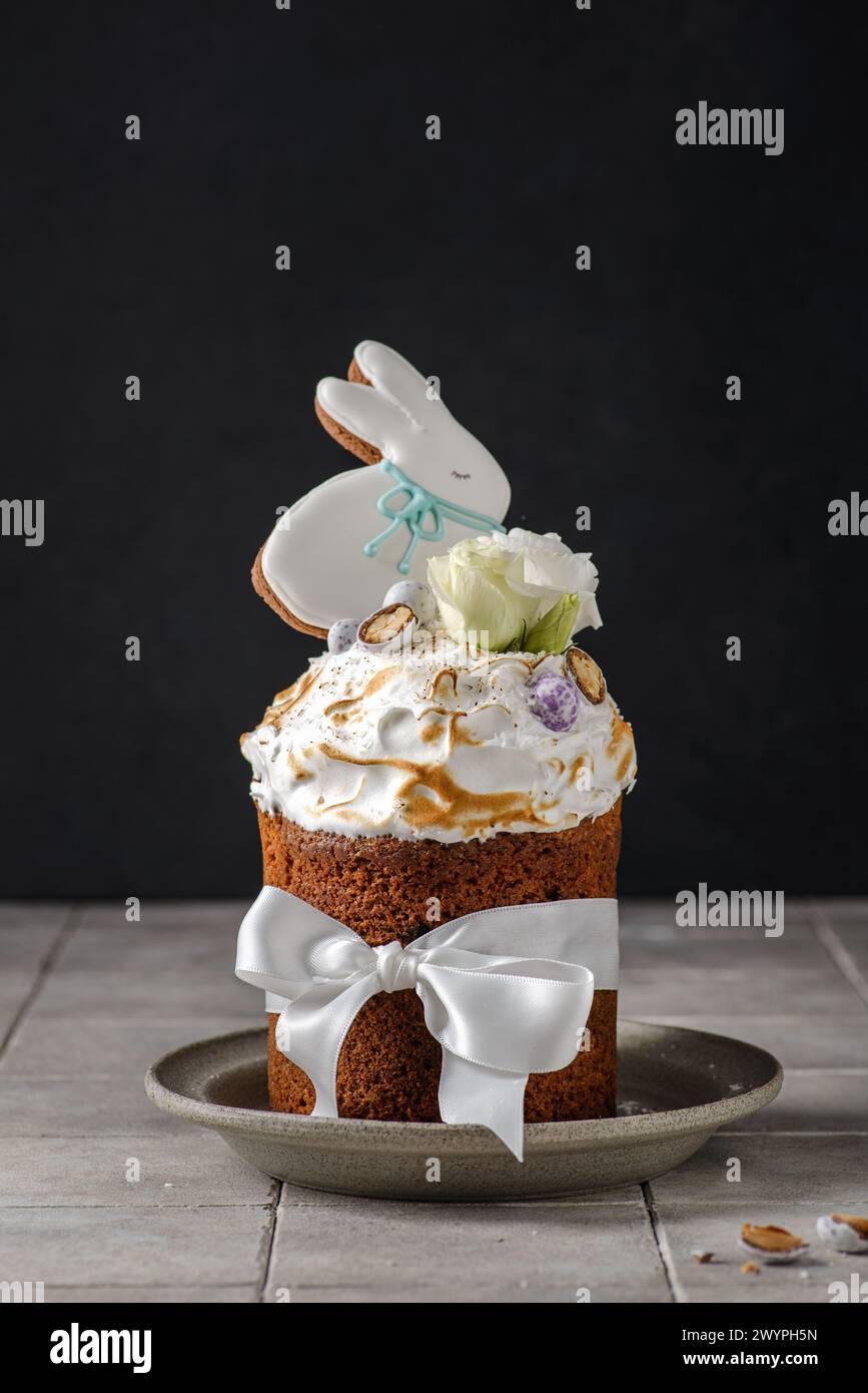 Easter cake on a dark background decorated with Easter chocolate eggs and Easter gingerbread rabbit Stock Photo