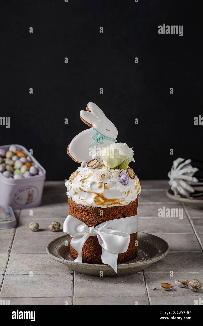 Easter cake on a dark background decorated with Easter chocolate eggs and Easter gingerbread rabbit Stock Photo