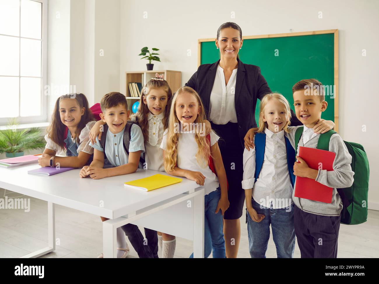 Classroom portrait of group of primary school students and their female teacher. Stock Photo