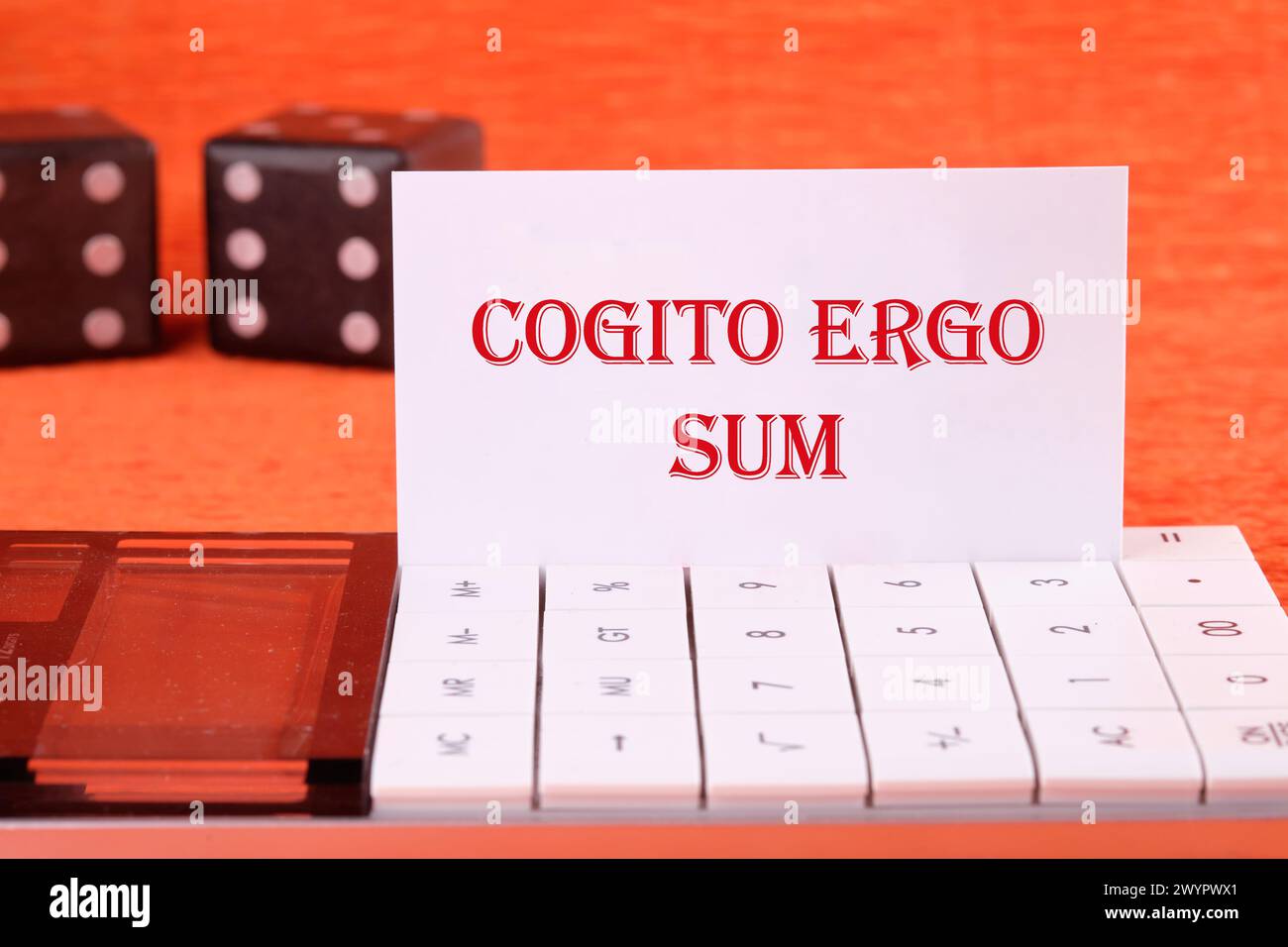 The words Cogito Ergo Sum or I think Therefore I Am on a white business card on a calculator on an orange background Stock Photo