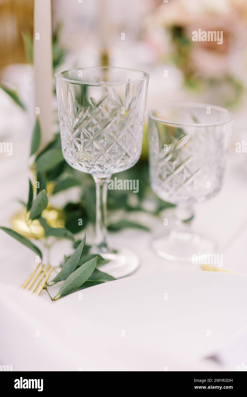 Elegant crystal glassware and gold cutlery on table Stock Photo