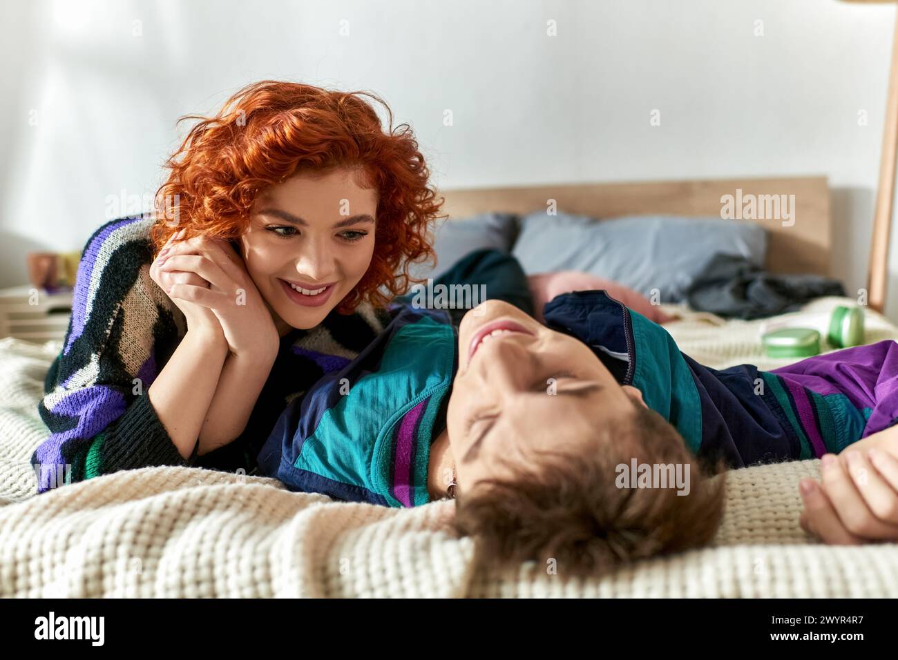red haired alluring woman looking lovingly at her handsome boyfriend ...