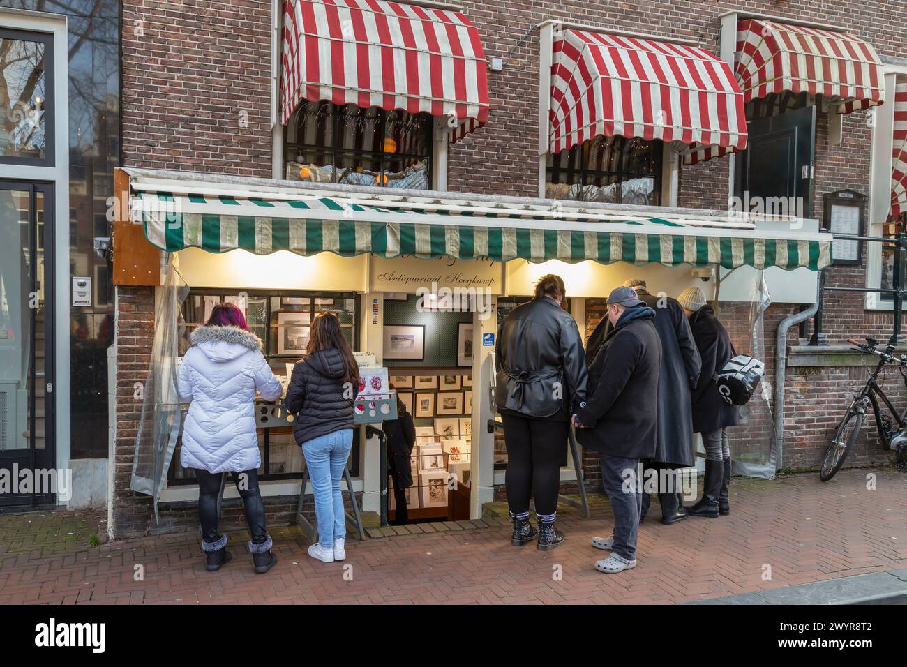People admire the prints in the antiquarian bookstore on Nieuwe Spiegelstraat in Amsterdam. Stock Photo