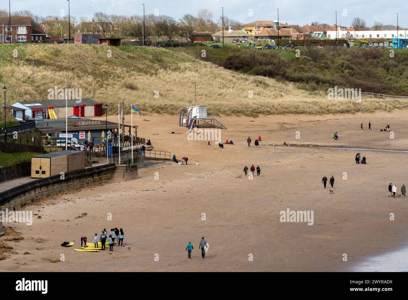 People on the beach by Crusoes cafe bar on the sea front known as Longsands or Long Sands in Tynemouth, North Tyneside, UK Stock Photo