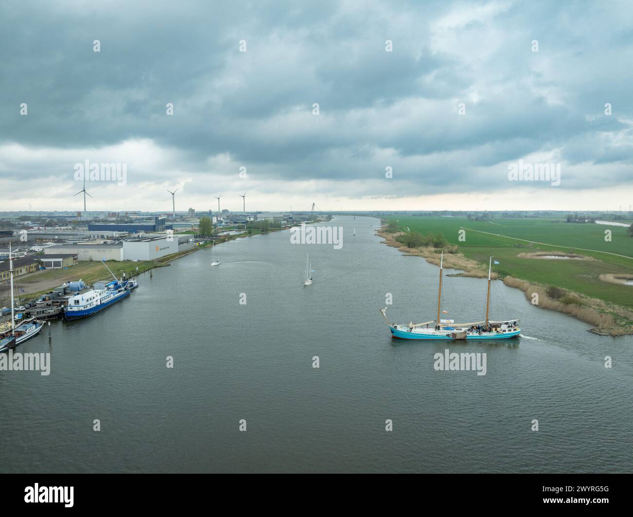 KAMPEN, NETHERLANDS - MARCH 30, 2024: Utopia clipper sail boat making a turn on the IJssel river. The ship is built in 1903 and has a length of 42 m. Stock Photo