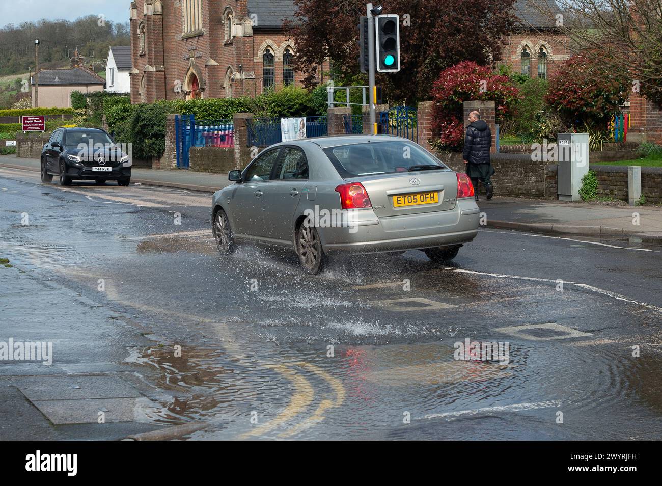 Chesham, Buckinghamshire, UK. 5th April, 2024. Water pours out of a blocked drain on a main road through Chesham, Buckinghamhire. Some cars were driving through the water at speed and splashing passers by. Credit: Maureen McLean/Alamy Stock Photo