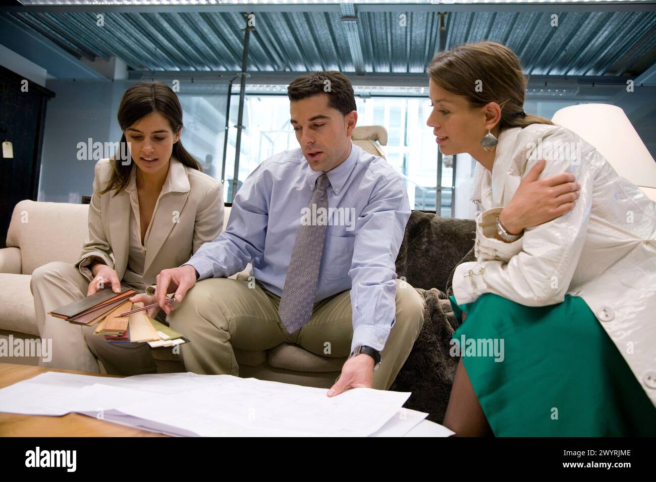 Three business people look plans hi-res stock photography and images ...