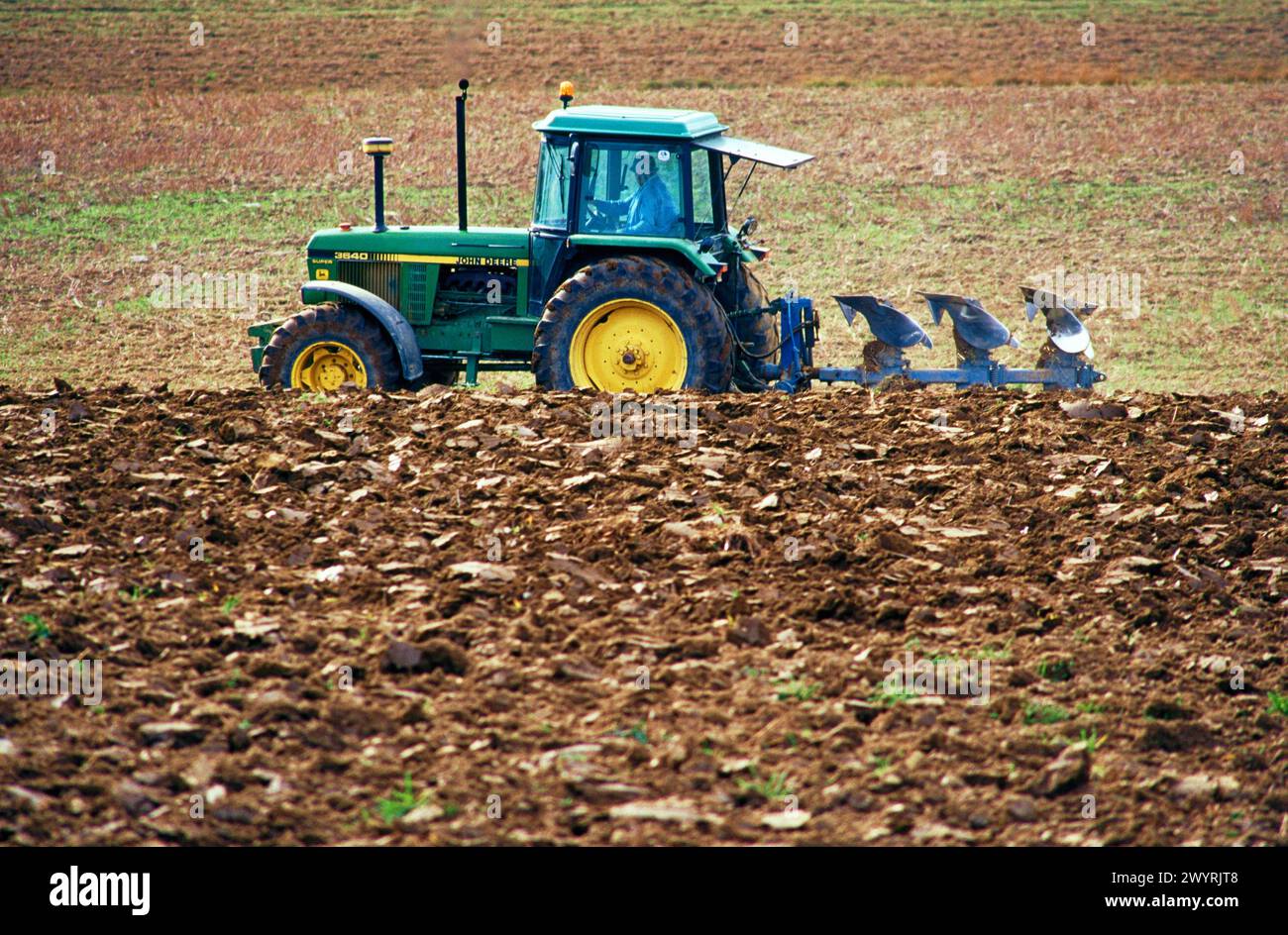 Tractor dragging a plough Stock Photo - Alamy