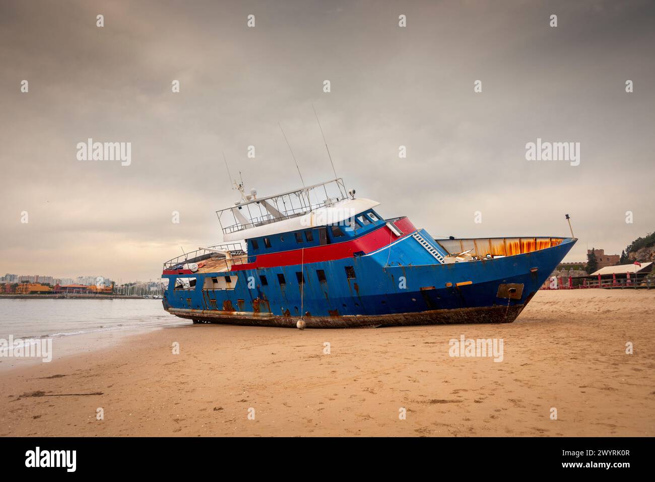 Boat washed up on a beach after storms, Algarve, Portugal Stock Photo