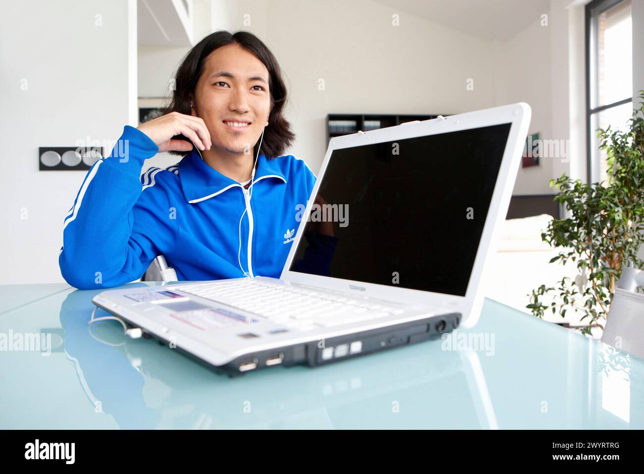 Japanese Man Using Computer Young Japanese man with laptop computer in room Stock Photo - Alamy